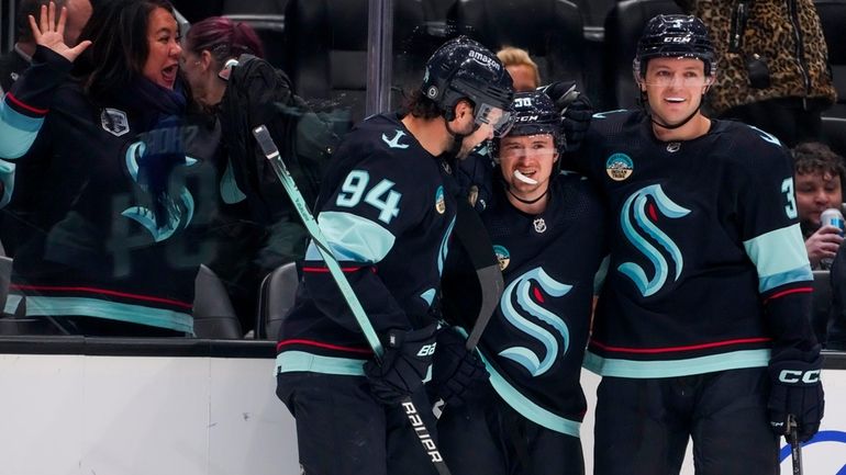 Seattle Kraken right wing Kailer Yamamoto, center, celebrates his goal...