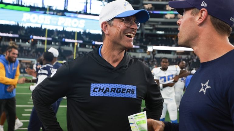 Los Angeles Chargers head coach Jim Harbaugh, center, talks to...