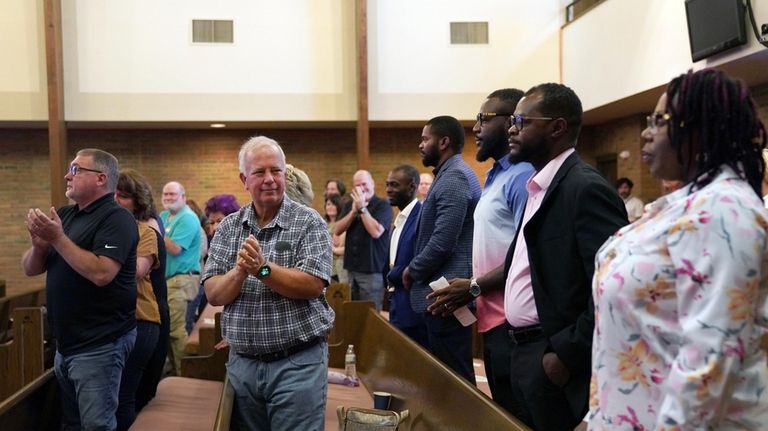 Central Christian Church congregants stand to applaud members of the...