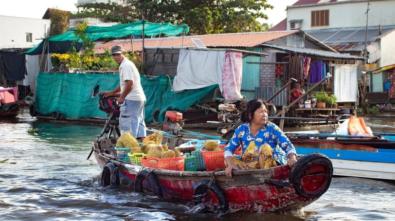 Vendors make their way through the water market at Cai...