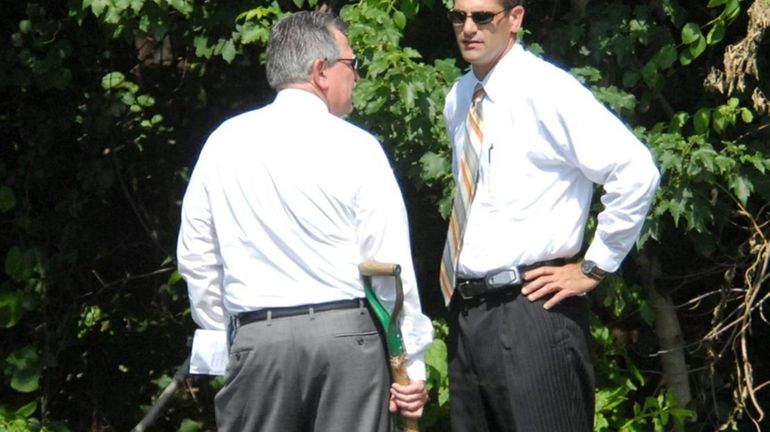 Homicide detectives in front of a wooded area on northbound...