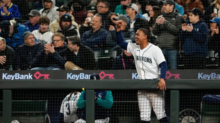 Seattle Mariners' Julio Rodriguez cheers from the dugout after Cal...