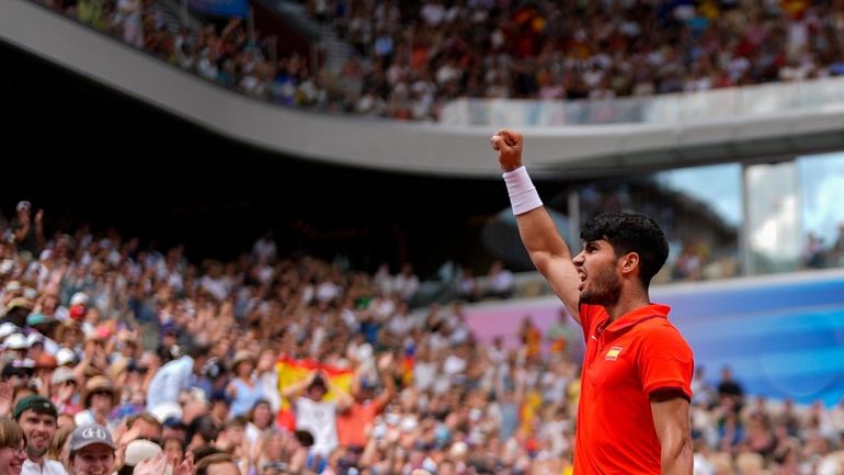 Carlos Alcaraz of Spain celebrates a point against Tommy Paul,...