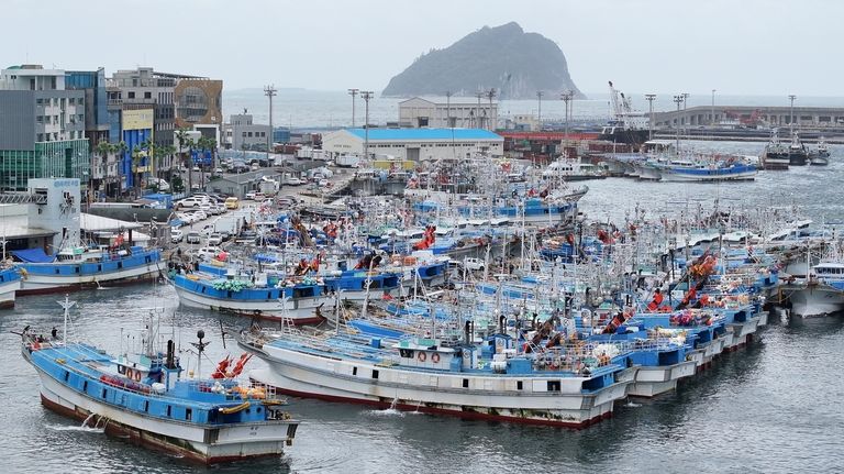 Fishing boats are anchored at a port as Typhoon Jongdari...