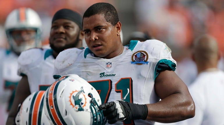 Dolphins tackle Jonathan Martin (71) watches from the sidelines during...