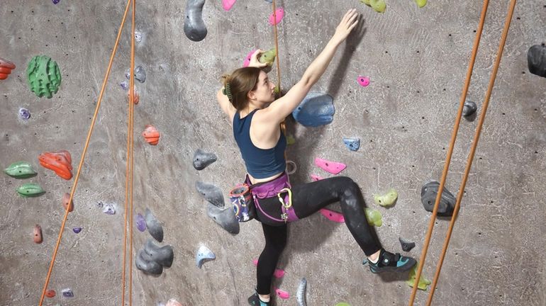 Sophie Renaud, of Farmingdale, ascends a wall at the Island Rock...