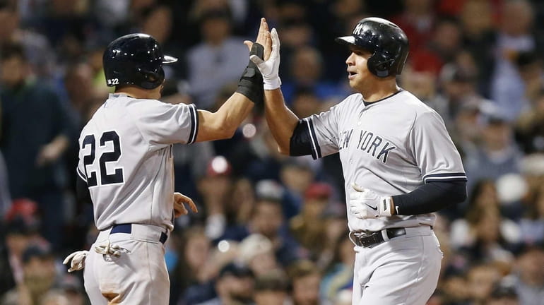 The New York Yankees' Alex Rodriguez, right, celebrates after scoring...