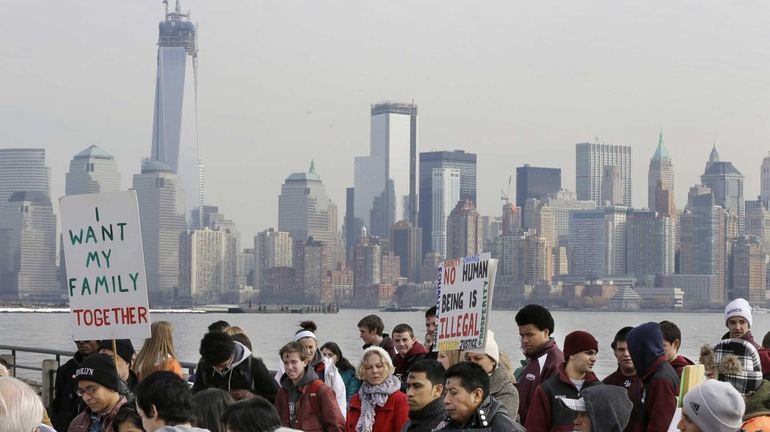 A group of immigrant rights advocates gather near Ellis Island...