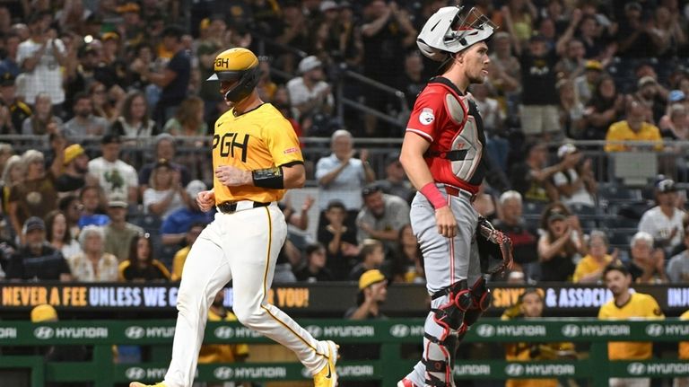 Pittsburgh Pirates catcher Joey Bart scores in front of Cincinnati...