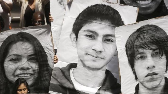 Supporters of the New York Dream Act hold photos of...