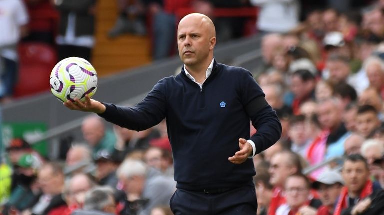 Liverpool's manager Arne Slot holds a ball during the English...