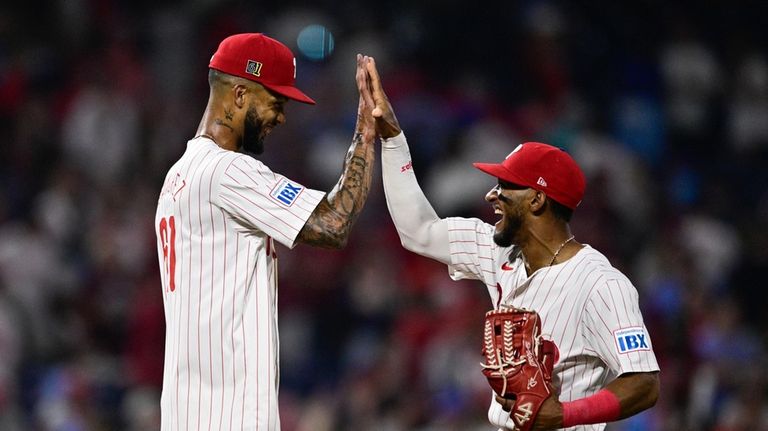 Philadelphia Phillies' Cristopher Sánchez, left, high-fives Johan Rojas after a...