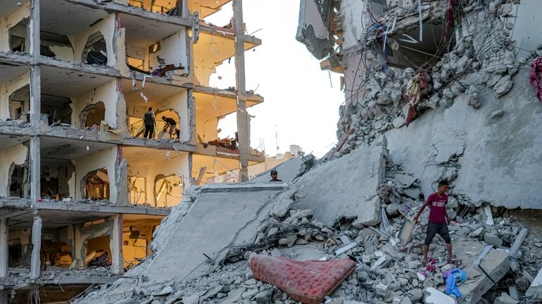 Palestinians inspect their houses after it was destroyed by the...