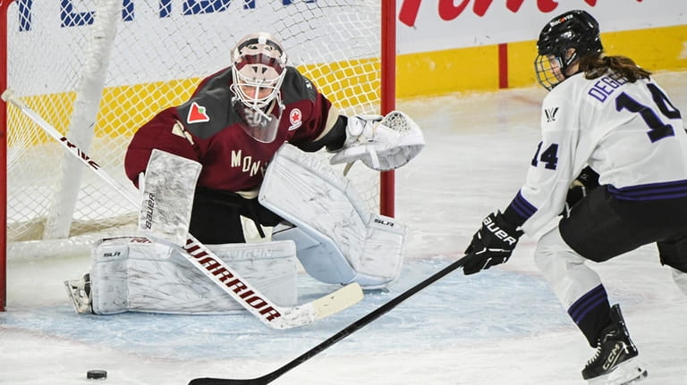 Minnesota's Clair DeGeorge (14) moves in on Montreal goaltender Elaine...