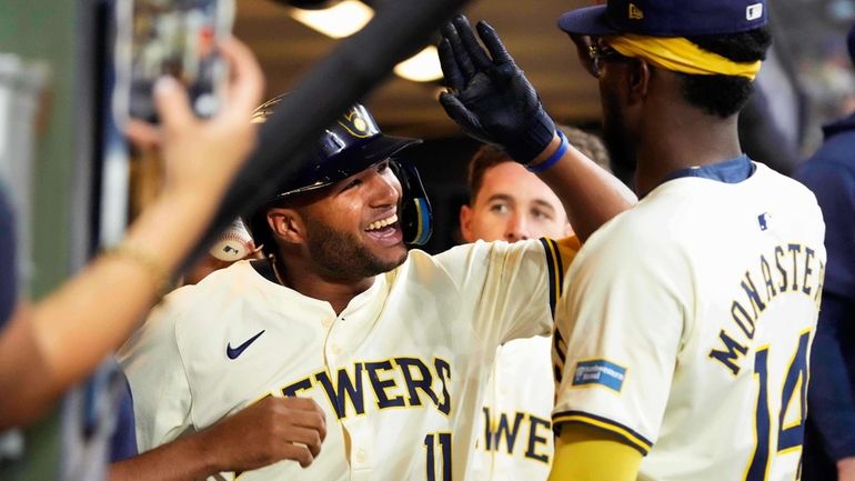 Milwaukee Brewers' Jackson Chourio (11) celebrates in the dugout after...