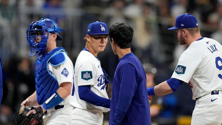 Los Angeles Dodgers starting pitcher Yoshinobu Yamamoto, second from left,...