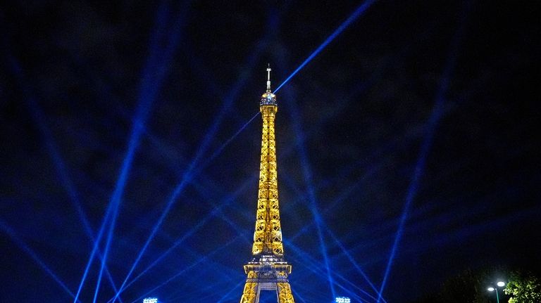 Search lights shine above Eiffel Tower Stadium, the beach volleyball...