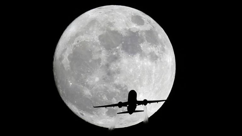 An American Airlines passenger plane passes in front of the...