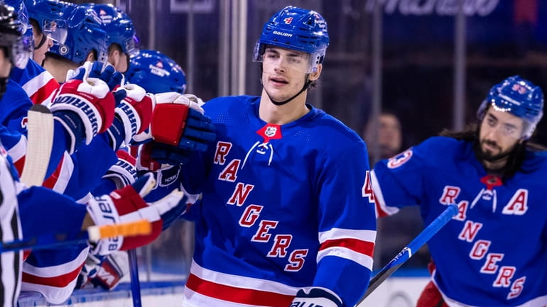 Rangers defenseman Braden Schneider celebrates his goal with the team...