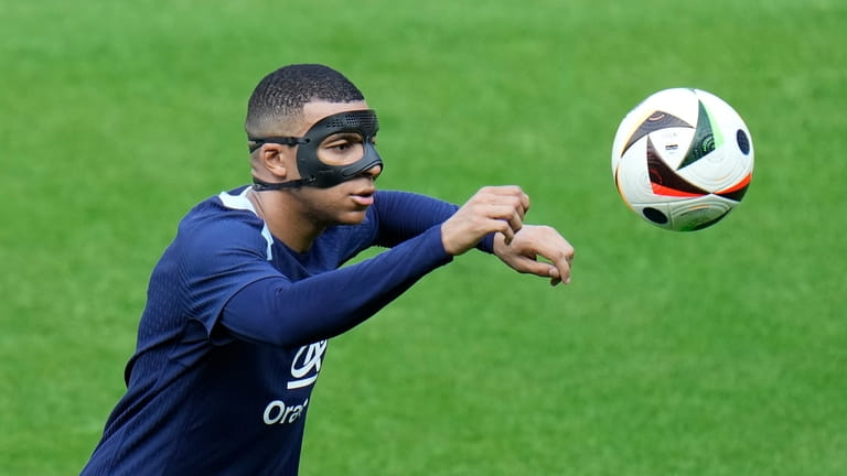 France's Kylian Mbappe eyes the ball during a training session...