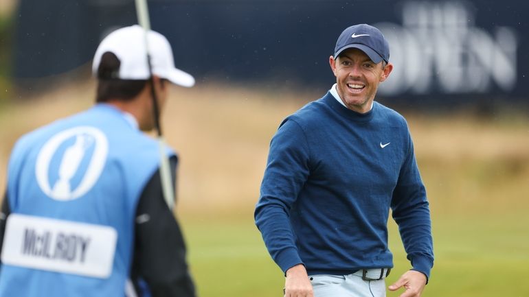 Rory McIlroy of Northern Ireland reacts with his caddy Harry...