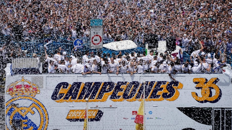 Real Madrid team players celebrate on an open-topped bus in...