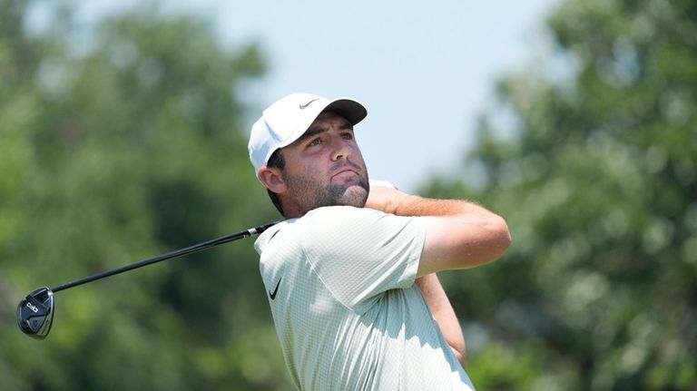 Scottie Scheffler hits a tee shot on the third hole...