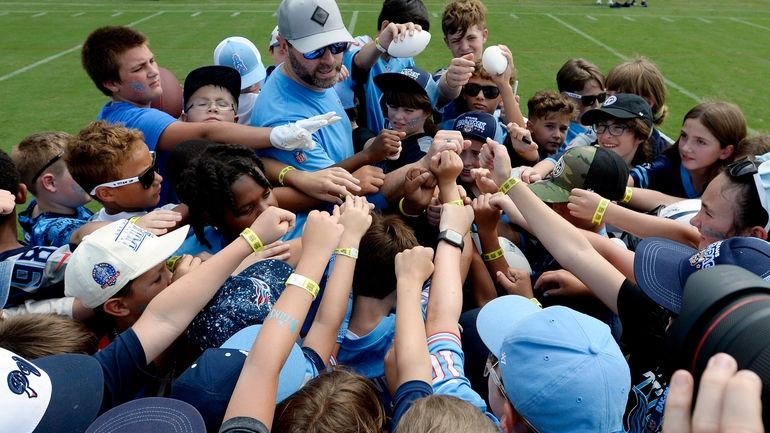 Tennessee Titans head coach Brian Callahan huddles with a group...