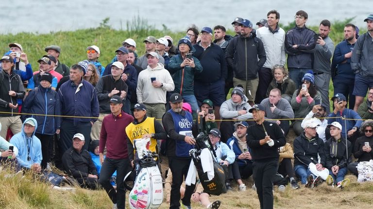 Xander Schauffele of the United States hits off the ninth...