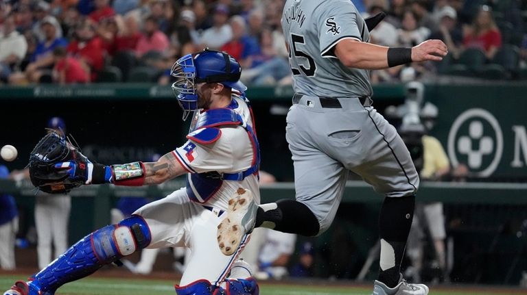 Texas Rangers catcher Jonah Heim, left, reaches for the throw...