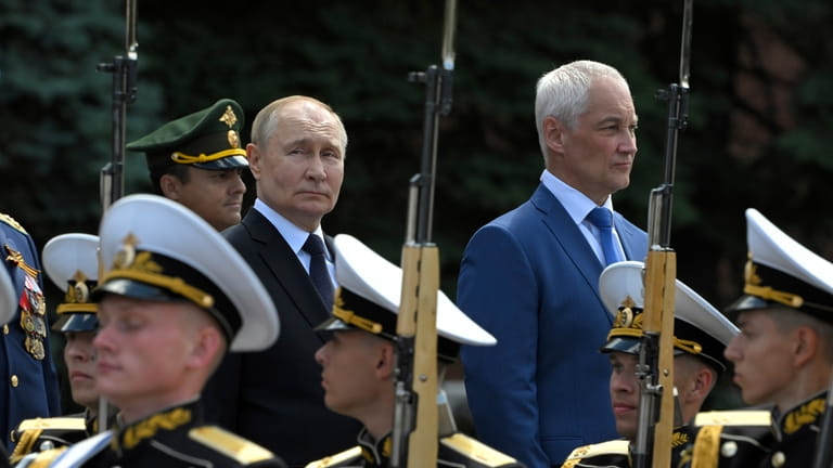 Russian President Vladimir Putin, background center, and Defense Minister Andrei...