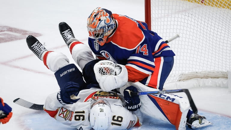 Florida Panthers' Aleksander Barkov (16) crashes into Edmonton Oilers goalie...