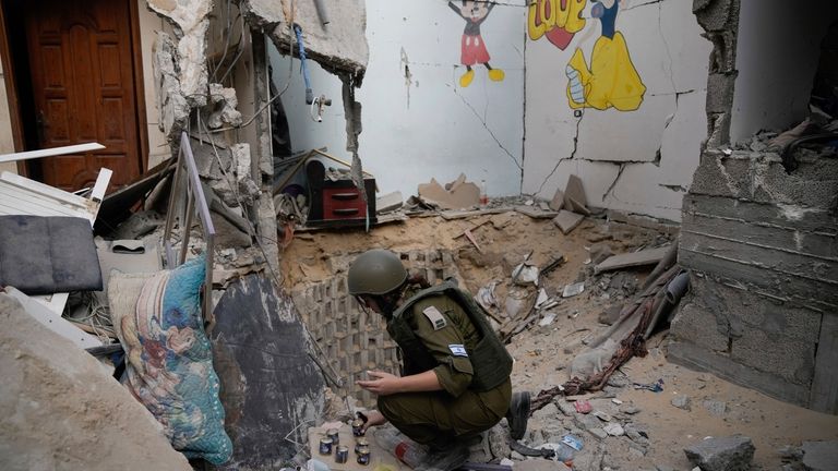 An Israeli soldier lights candles at the entrance of a...