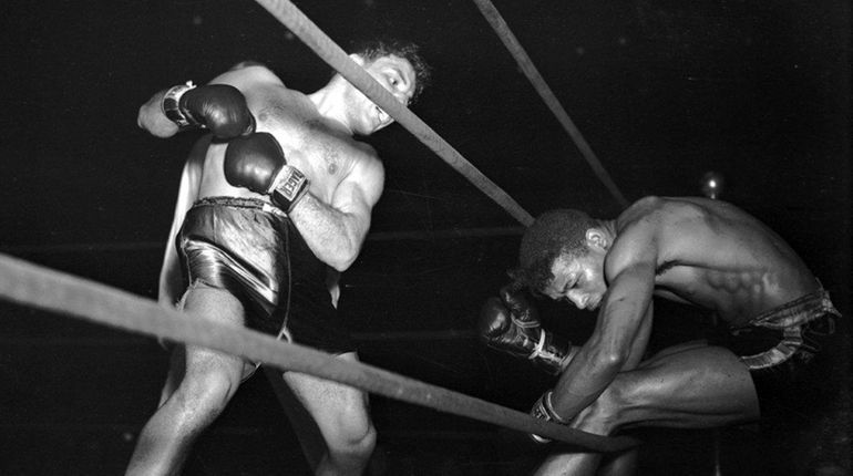 Jake La Motta, left, knocks Sugar Ray Robinson through the...