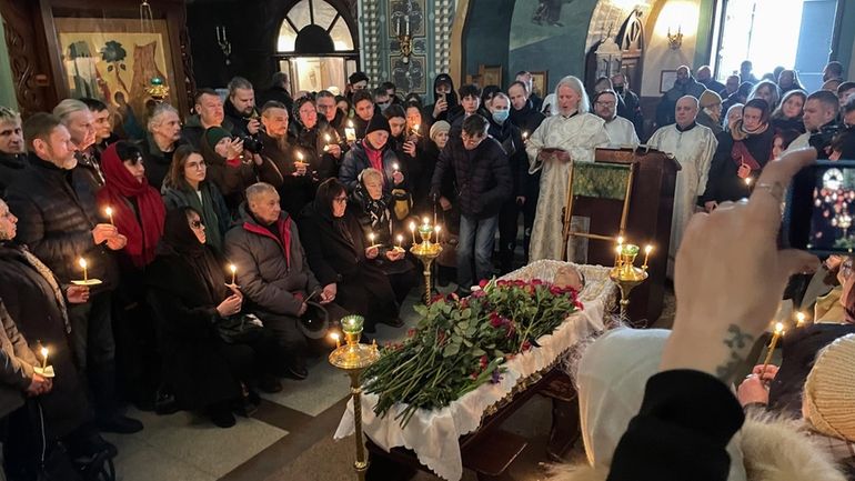 Relatives and friends pay their last respects at the coffin...