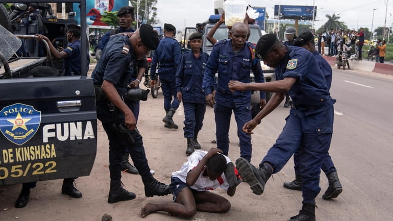 Security forces assault a supporter of presidential candidate Martin Fayulu...
