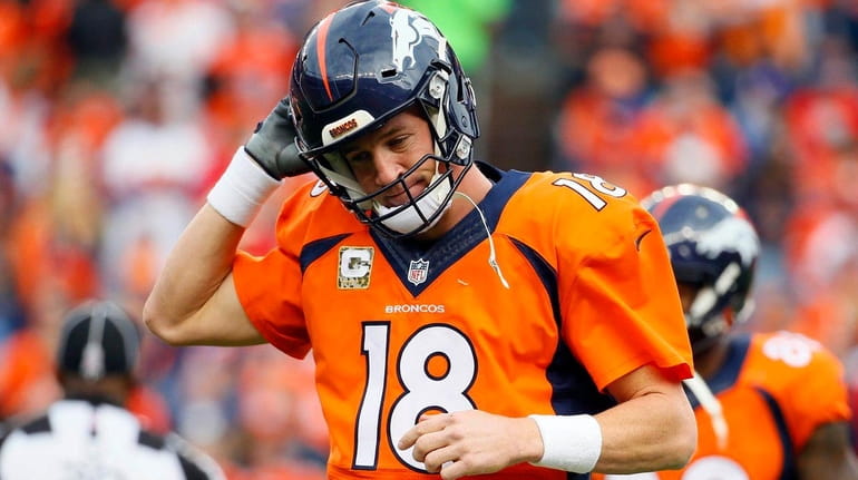 Denver Broncos quarterback Peyton Manning takes off his helmet after...