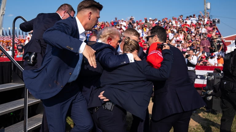 Republican presidential candidate former President Donald Trump is helped off...