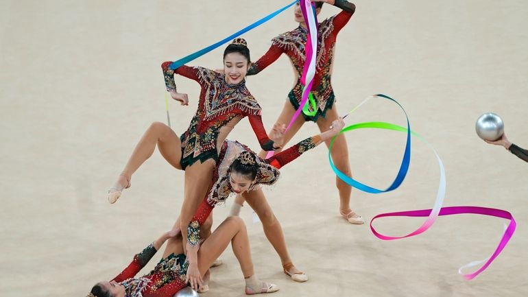 Team China performs with ribbons and balls in the group...