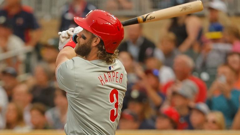 Philadelphia Phillies' Bryce Harper follows through on a two-run home...