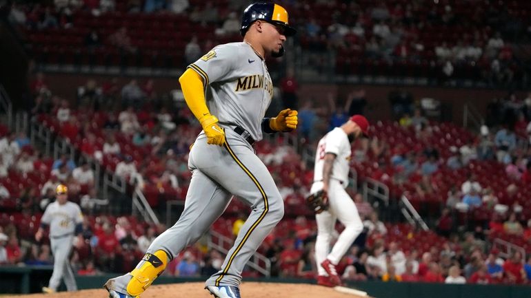 Milwaukee Brewers' William Contreras, left, rounds the bases after hitting...