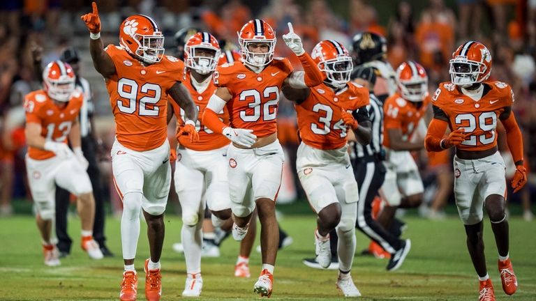 Clemson defensive end Levi Matthews (92) celebrates his interception in...