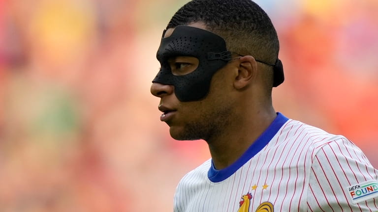 Kylian Mbappe of France wears a face mask during a...