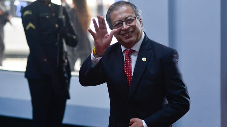 Colombian President Gustavo Petro waves to the press as he...