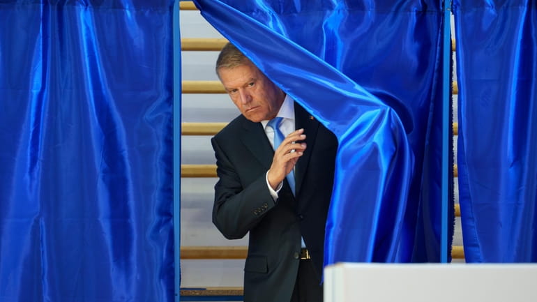 Romanian President klaus Iohannis exits a voting cabin during European...