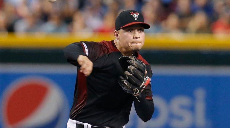 Arizona Diamondbacks third baseman Wilmer Flores, top, makes an out...