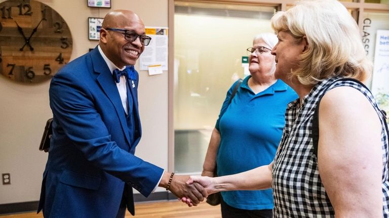 Dr. Claude Tiller Jr. shakes hands at the Aging &...