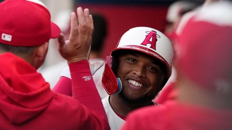 Los Angeles Angels' Willie Calhoun is congratulated by teammates in...