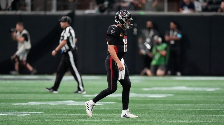 Atlanta Falcons quarterback Kirk Cousins walks off the field after...