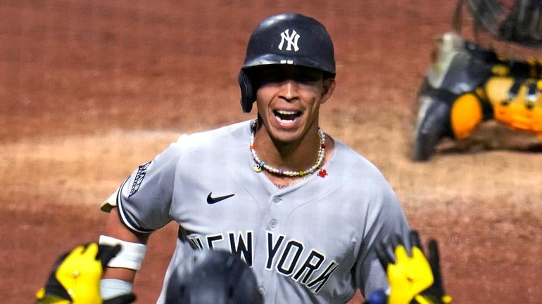 Yankees' Oswaldo Cabrera, top, is greeted by Aaron Judge as...